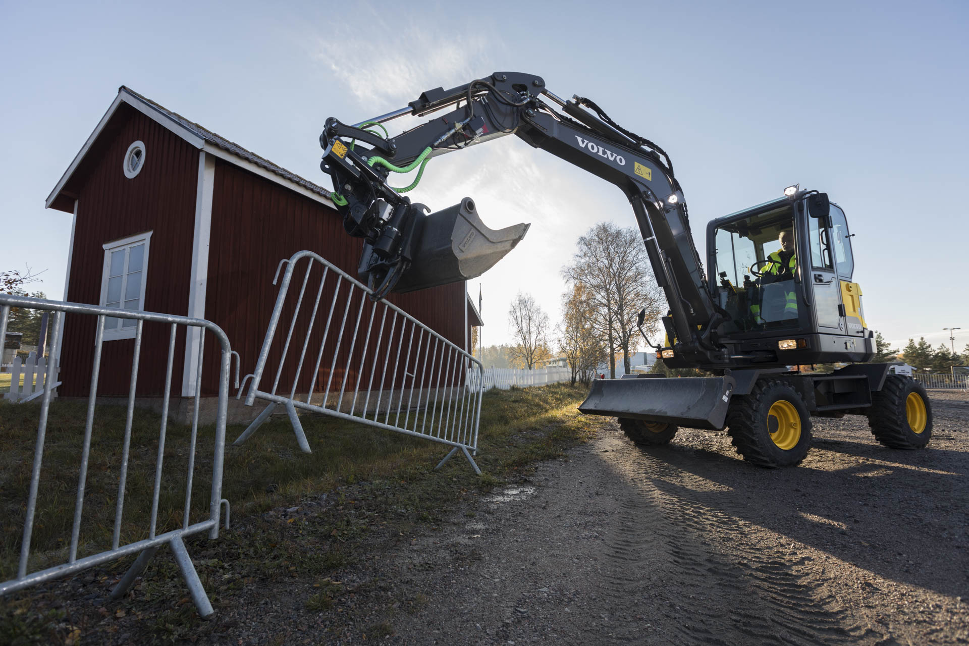 En entreprenadmaskin i arbete en tidig höstmorgon. Knallblå bakgrund.